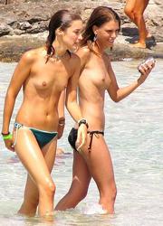 A busty bikini slut undressing on the Coralita Image 2