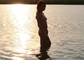 My romantic girlfriend with pretty small tits loves swimming nude on some lonely beach at sunset. Image 1